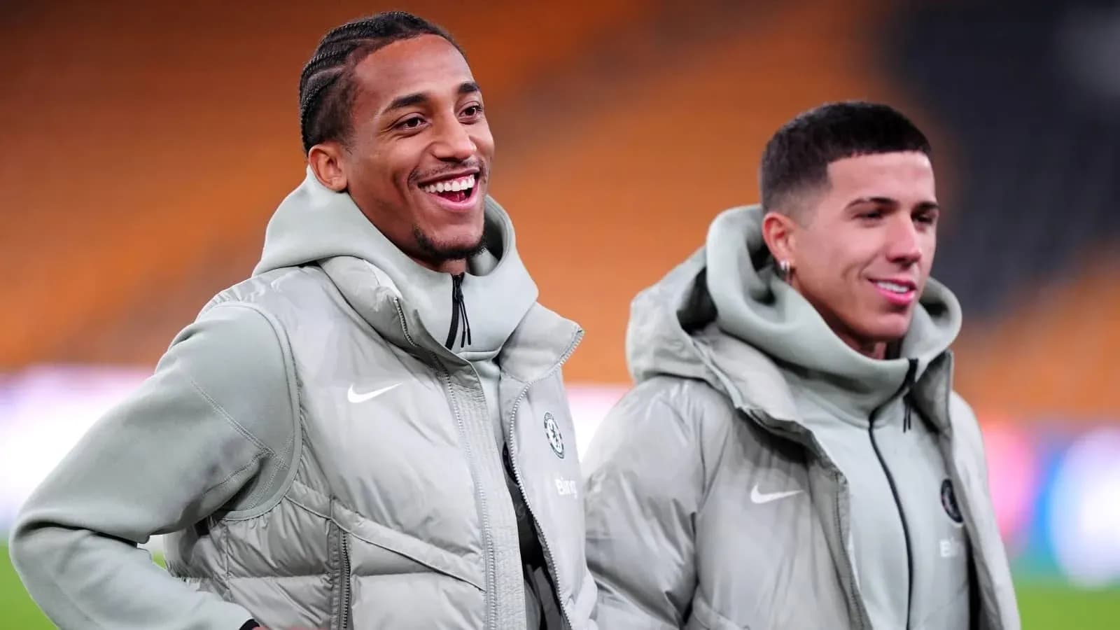 Two players smiling in matching gray jackets