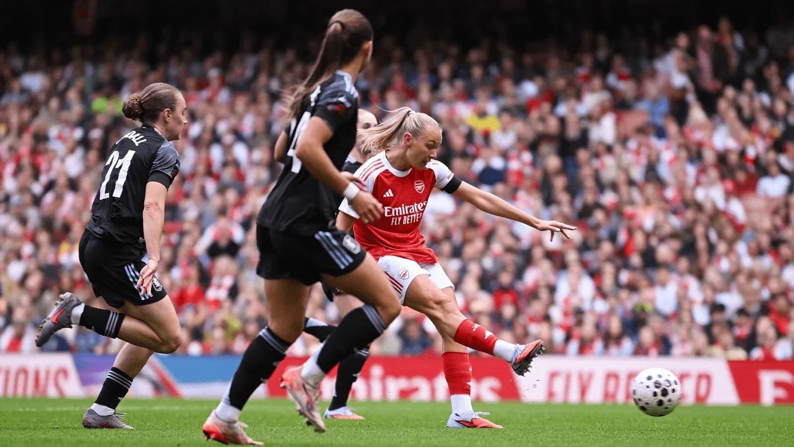 Arsenal player shooting at goal during match