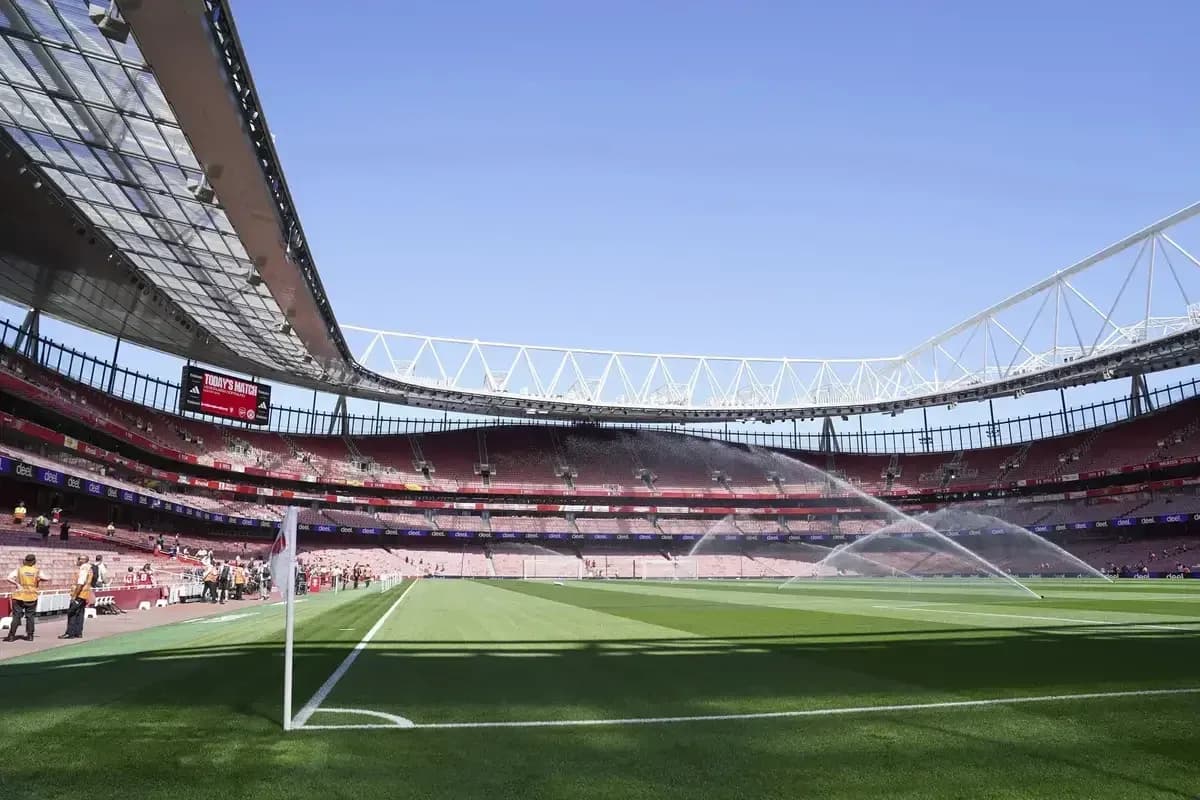 Empty stadium with sprinklers watering the pitch
