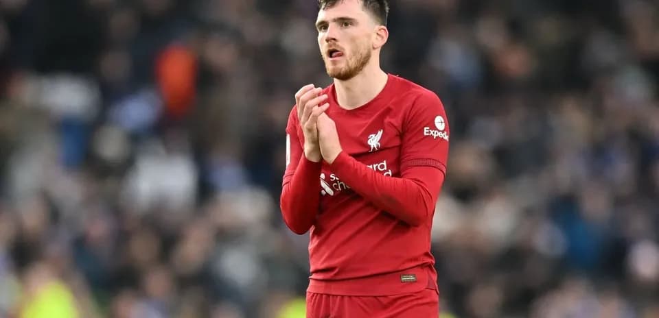 Player in Liverpool jersey applauding crowd