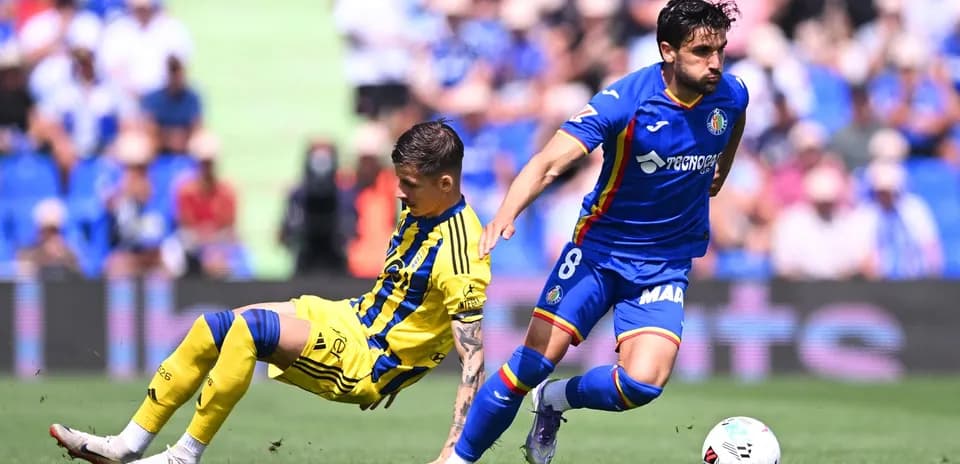 Getafe player tackling Oviedo opponent during match