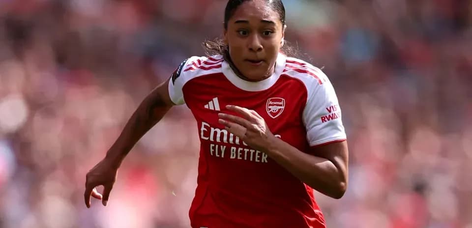Player sprinting on the field in Arsenal kit