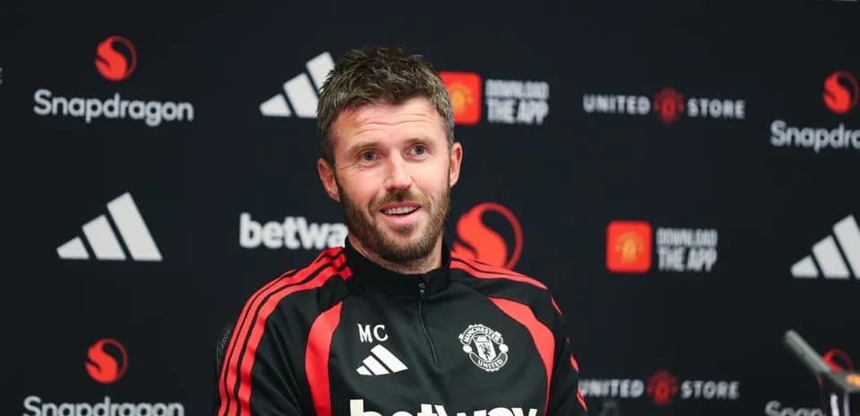 Manager speaking at press conference with Manchester United backdrop