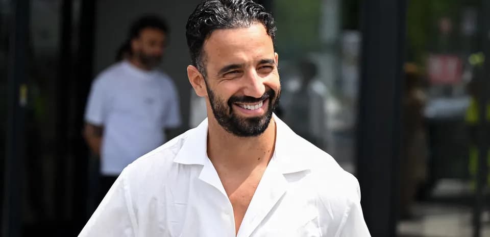 Smiling man in white shirt walking outside