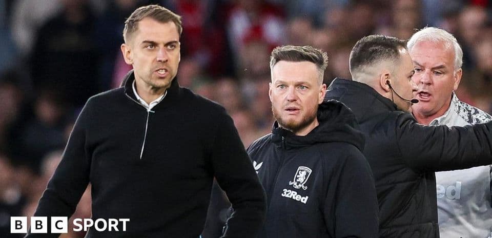Coaches interacting during a tense moment on pitch
