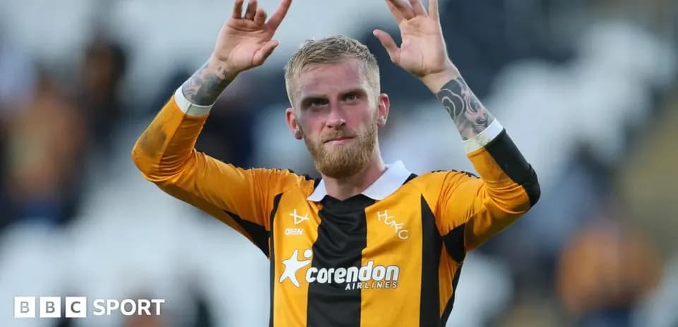 Player waving to fans after match in team jersey
