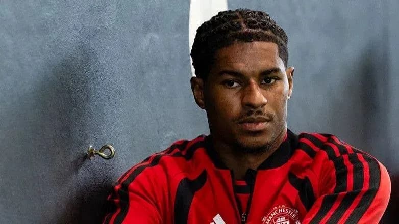 Player in Manchester United training kit posing for photo