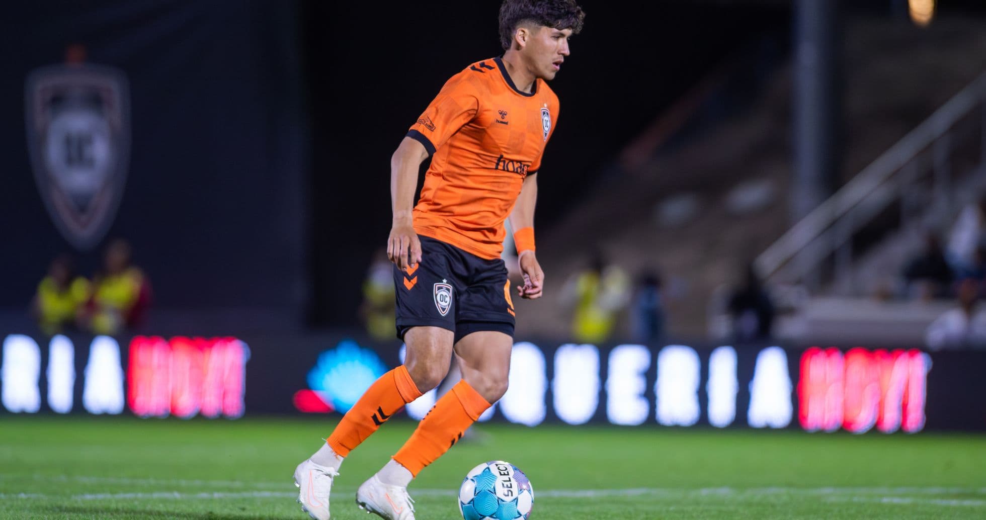 Player in orange kit controlling the ball