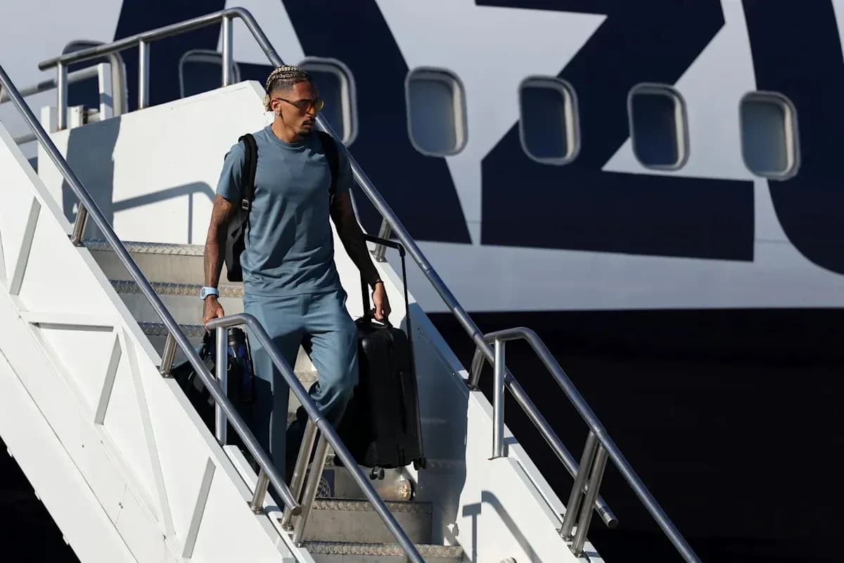 Player descending airplane steps with luggage
