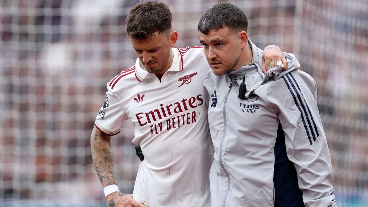 Player being assisted off the pitch by staff