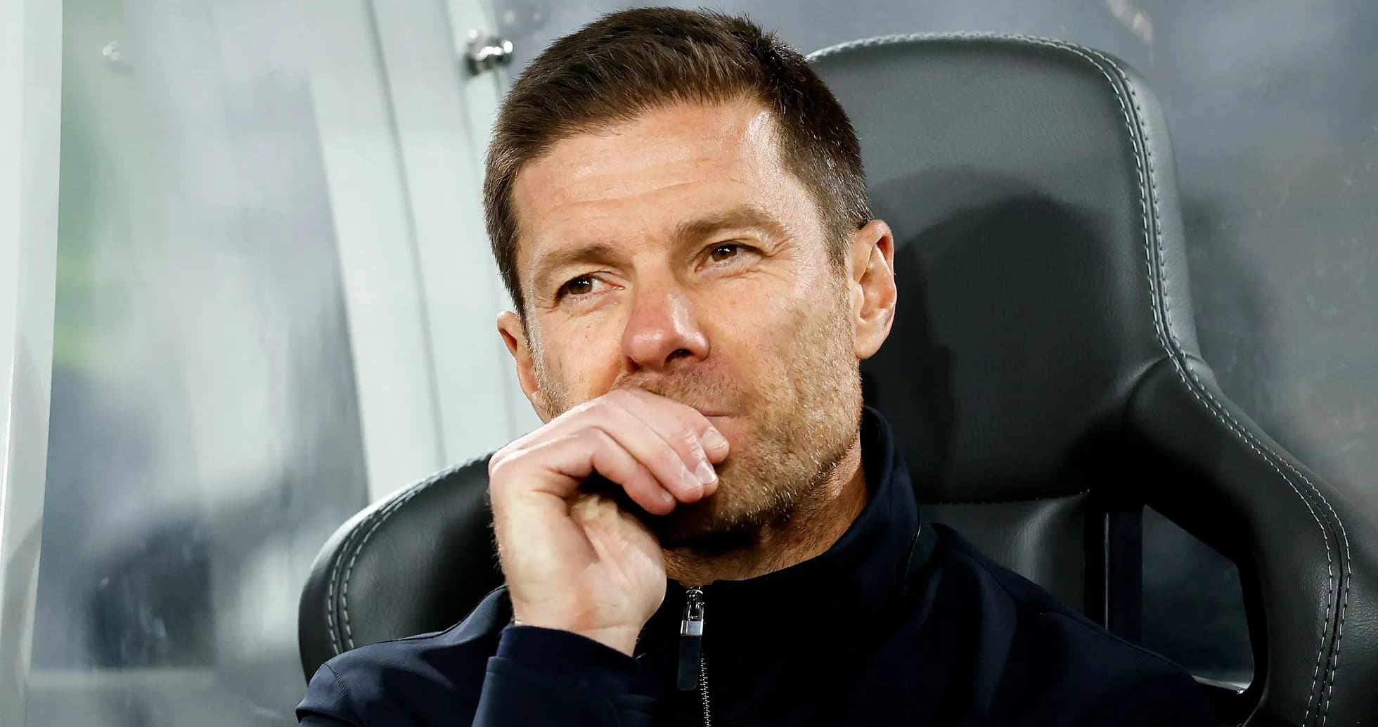 Coach seated on bench during a match