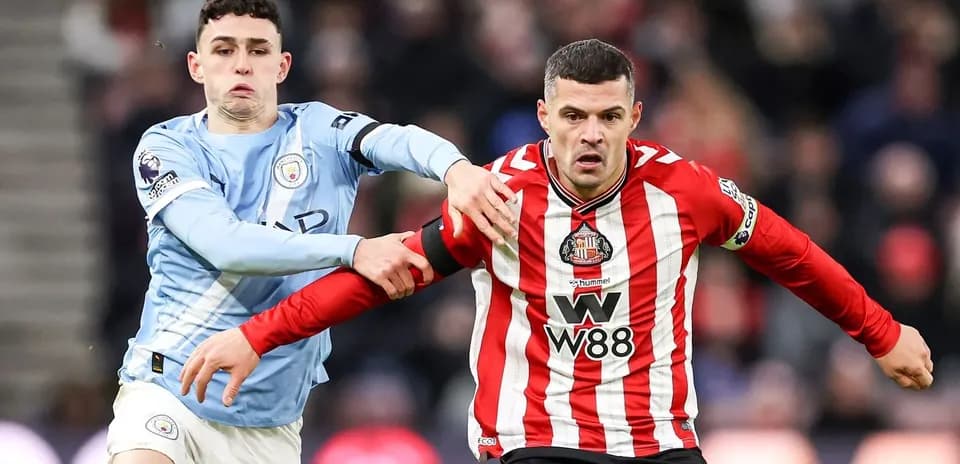Manchester City player challenging Sunderland opponent
