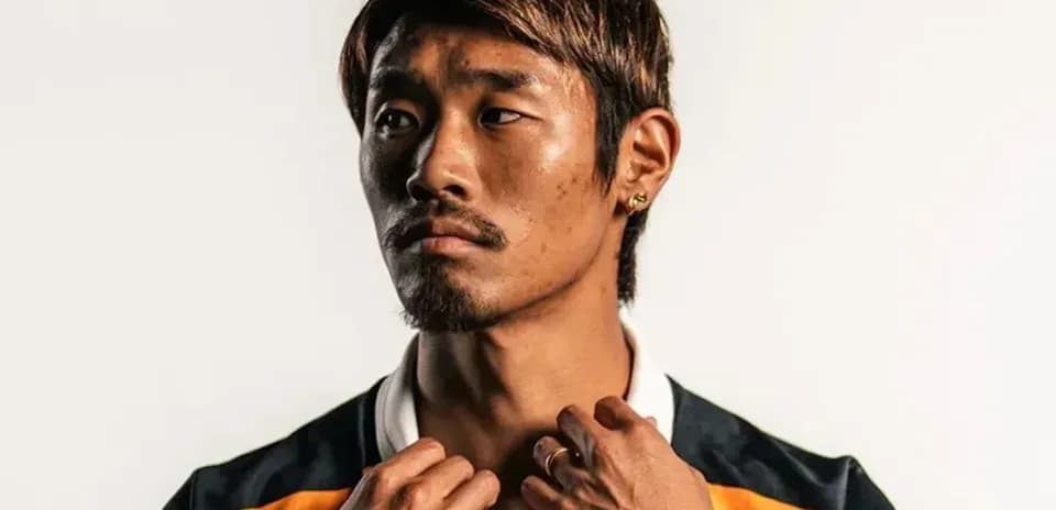Athlete posing in team jersey against white background