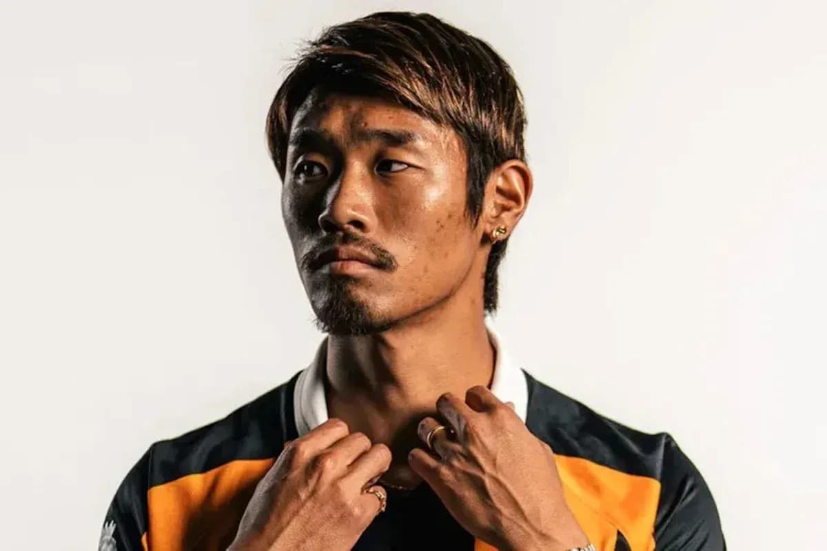 Athlete posing in team jersey against white background
