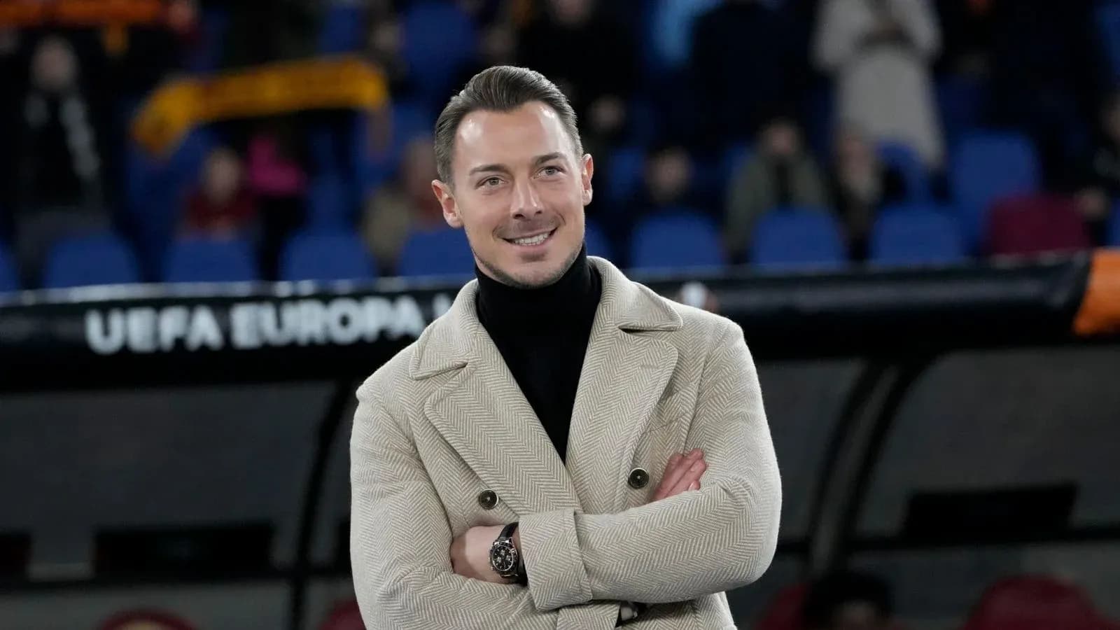 Man in stylish coat at a football match