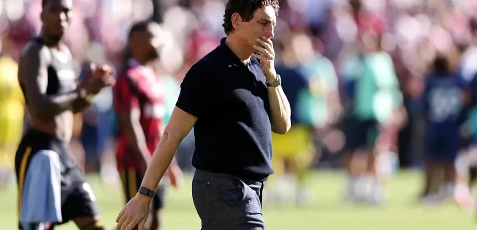 Coach walking off the pitch after the match