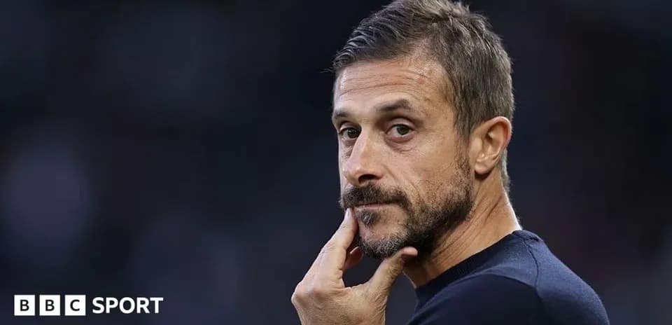 Coach observing the match with thoughtful expression