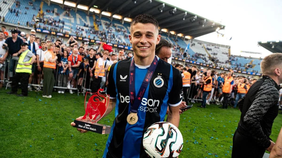 Player celebrating with trophy and ball on field