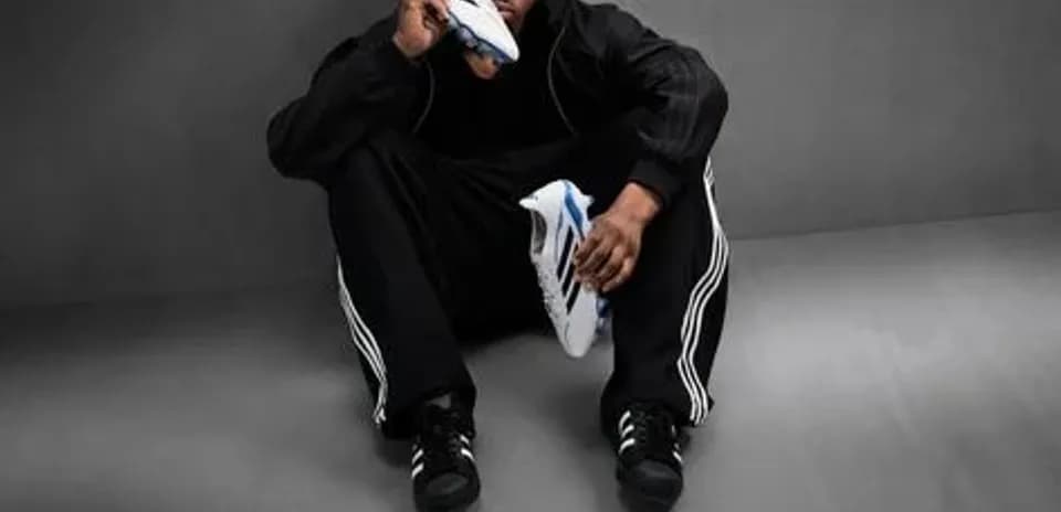 Athlete sitting on floor holding soccer shoe