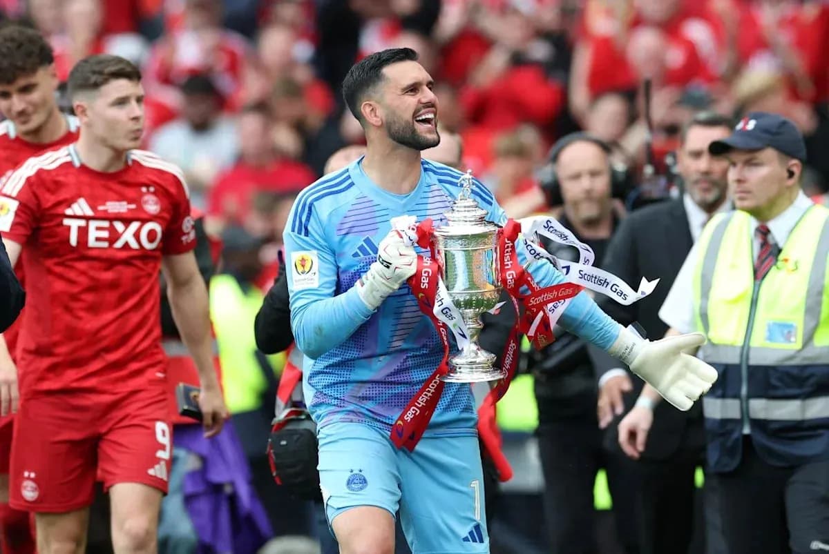 Goalkeeper celebrating with the trophy after match
