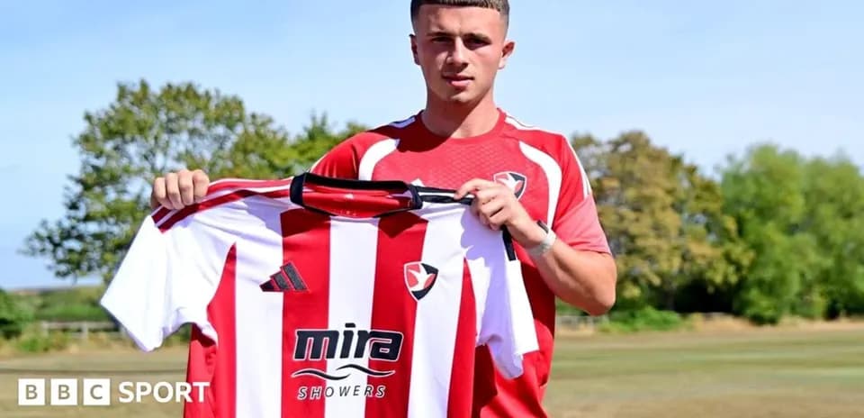 Player holding Cheltenham Town jersey during presentation