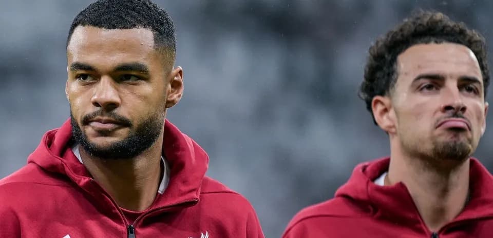 Two Liverpool players in warm-up jackets before match