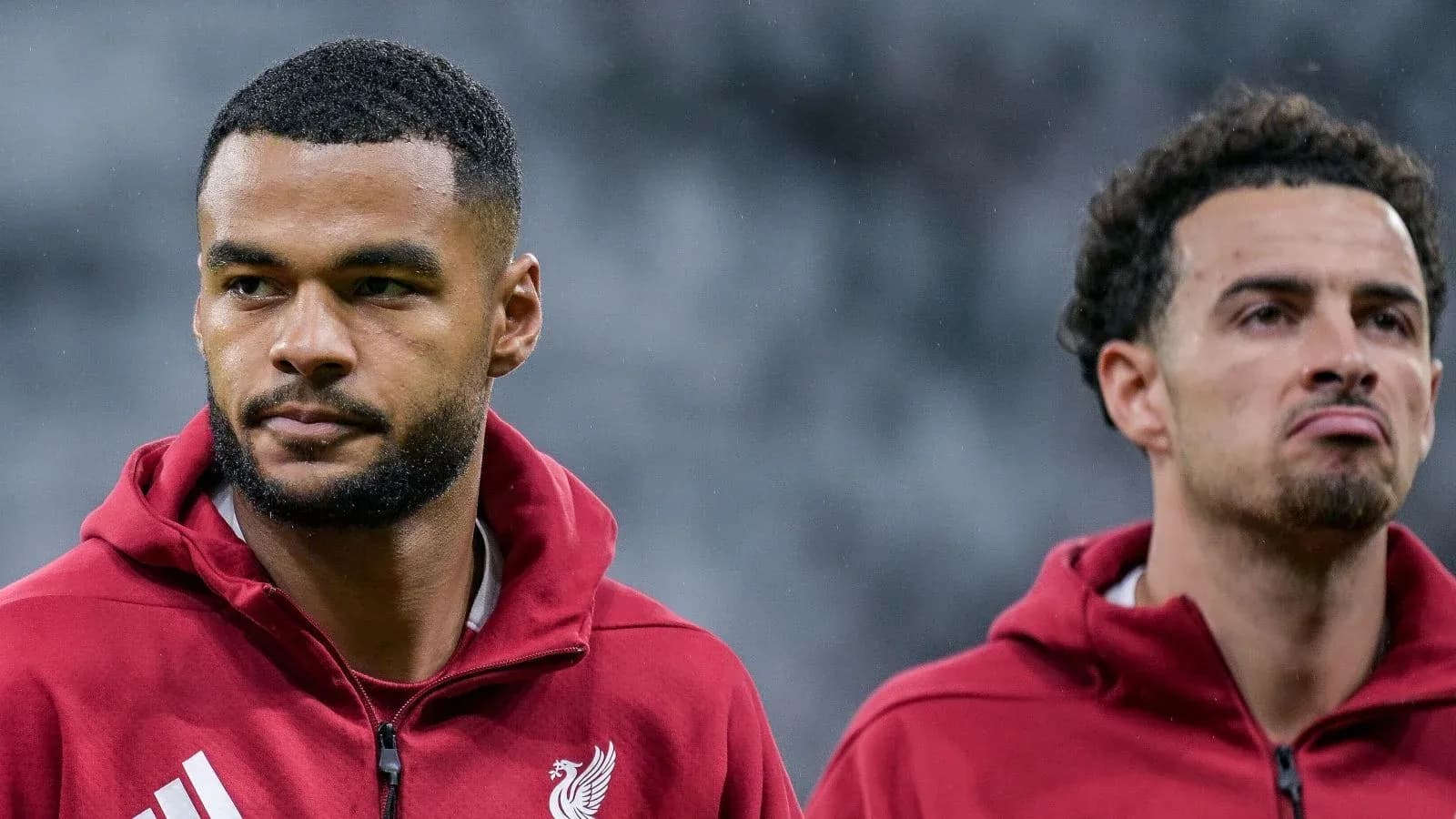 Two Liverpool players in warm-up jackets before match