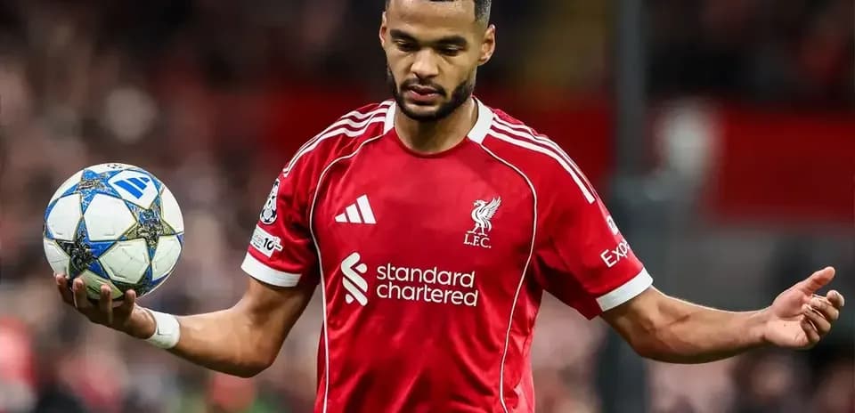 Player in red Liverpool jersey holding a football