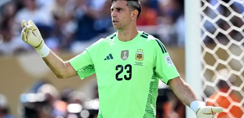 Goalkeeper in green uniform directing play on field