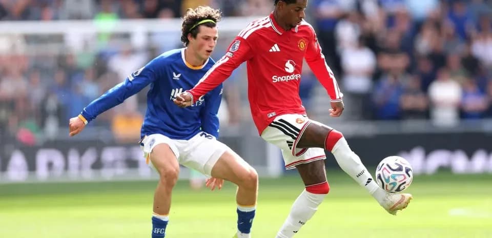 Manchester United player dribbling past opponent during match