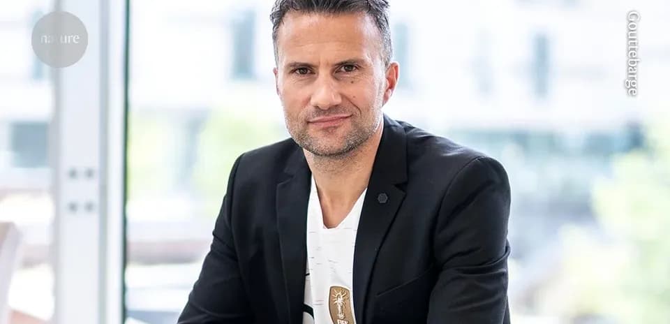 Man in black blazer sitting indoors