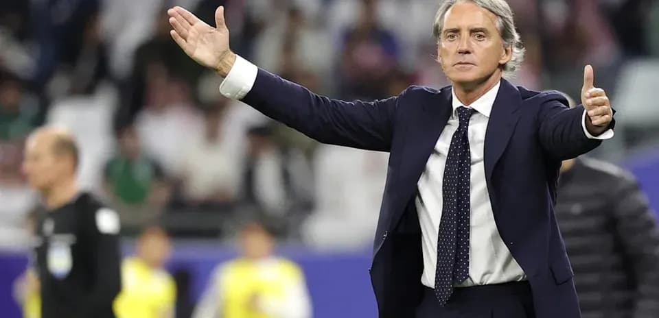 Coach gesturing during a football match on the sidelines