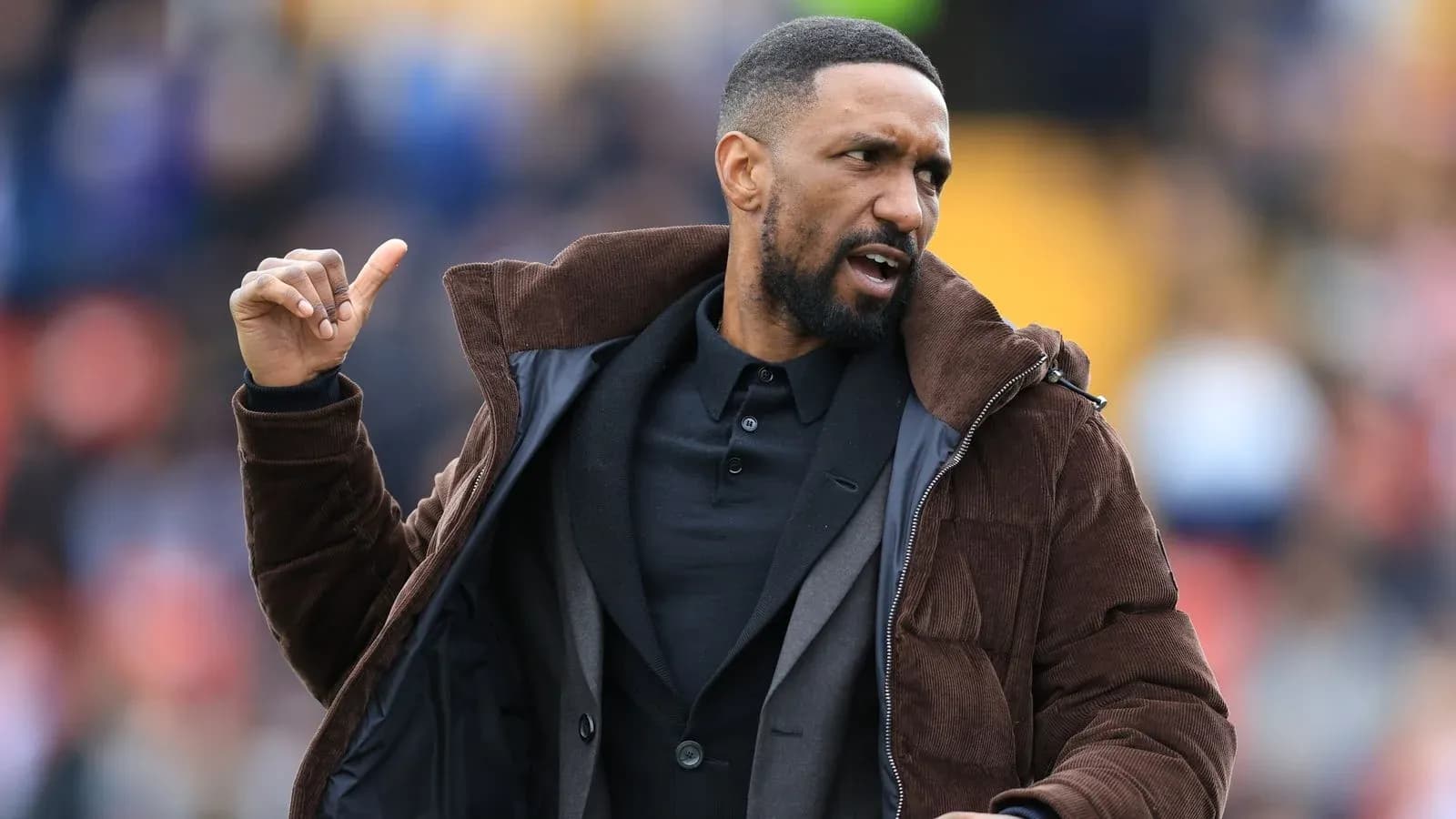 Coach gesturing during a match on the sidelines