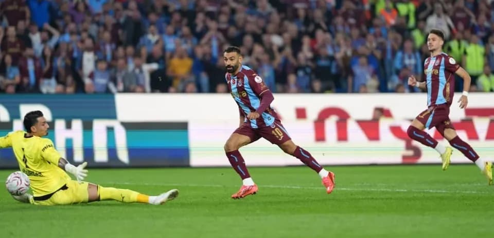 Player scoring against goalkeeper in intense match
