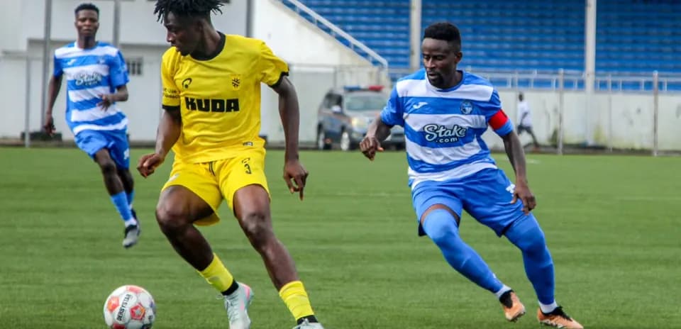 Kano Pillars player dribbling past Enyimba defender