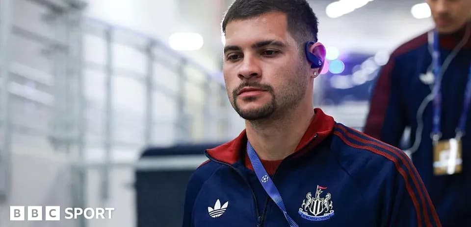 Player entering stadium wearing Newcastle tracksuit