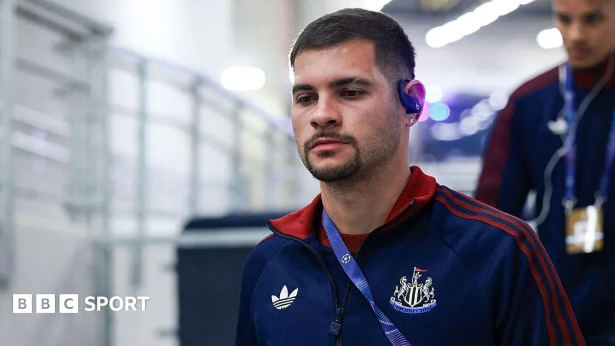 Player entering stadium wearing Newcastle tracksuit