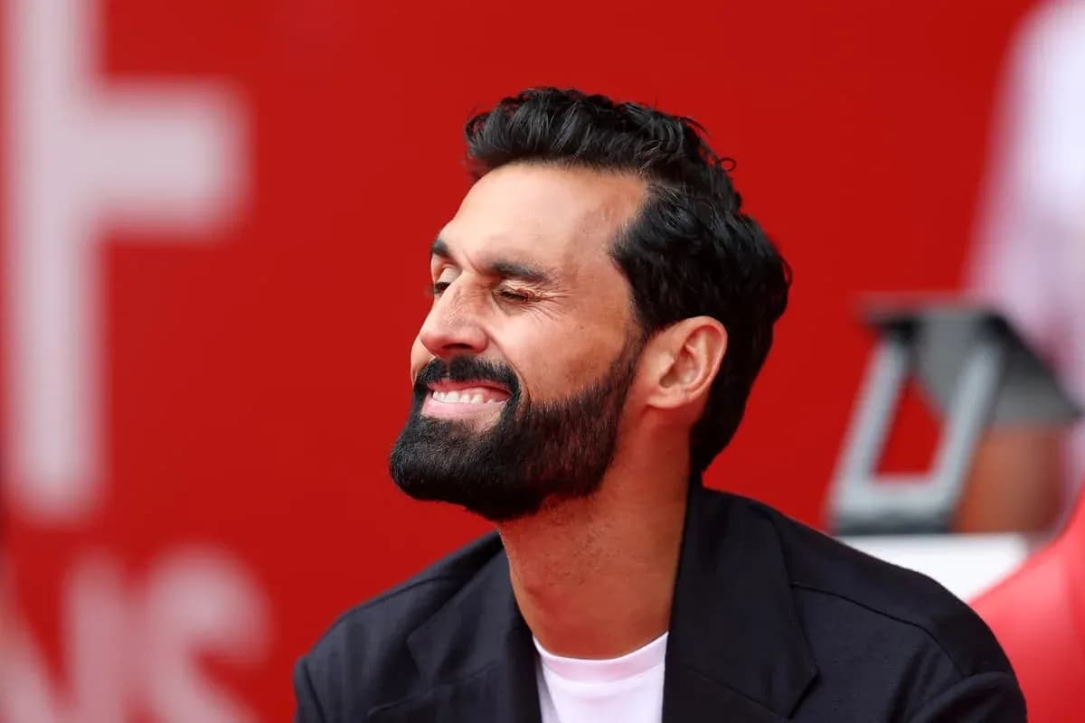 Man smiling while seated on bench with red background