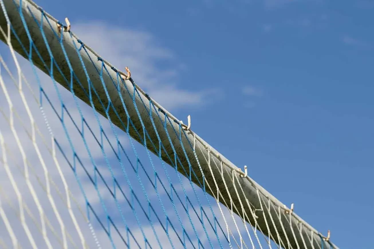 Close-up of a goal net against blue sky