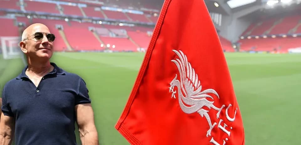Man standing near Liverpool FC flag at stadium