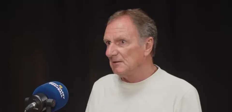 Man speaking at a microphone during an interview