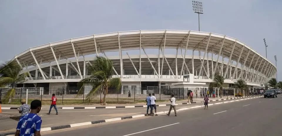 Exterior view of a modern stadium with pedestrians