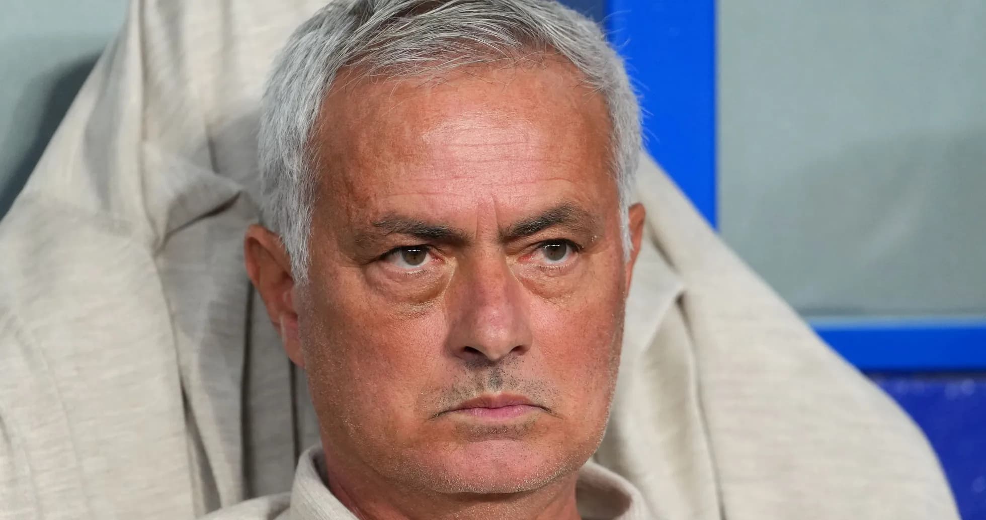 Coach seated during match, focused on game
