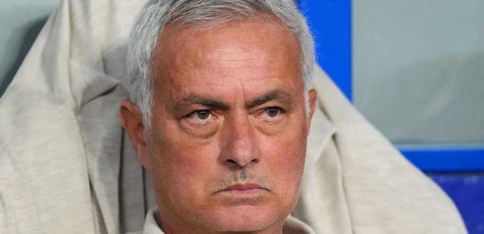 Coach seated during match, focused on game