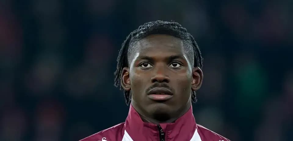 Player in maroon training jacket during match preparation