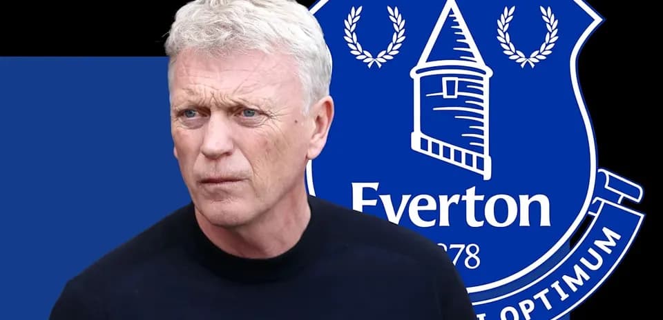 Coach in front of Everton club logo background