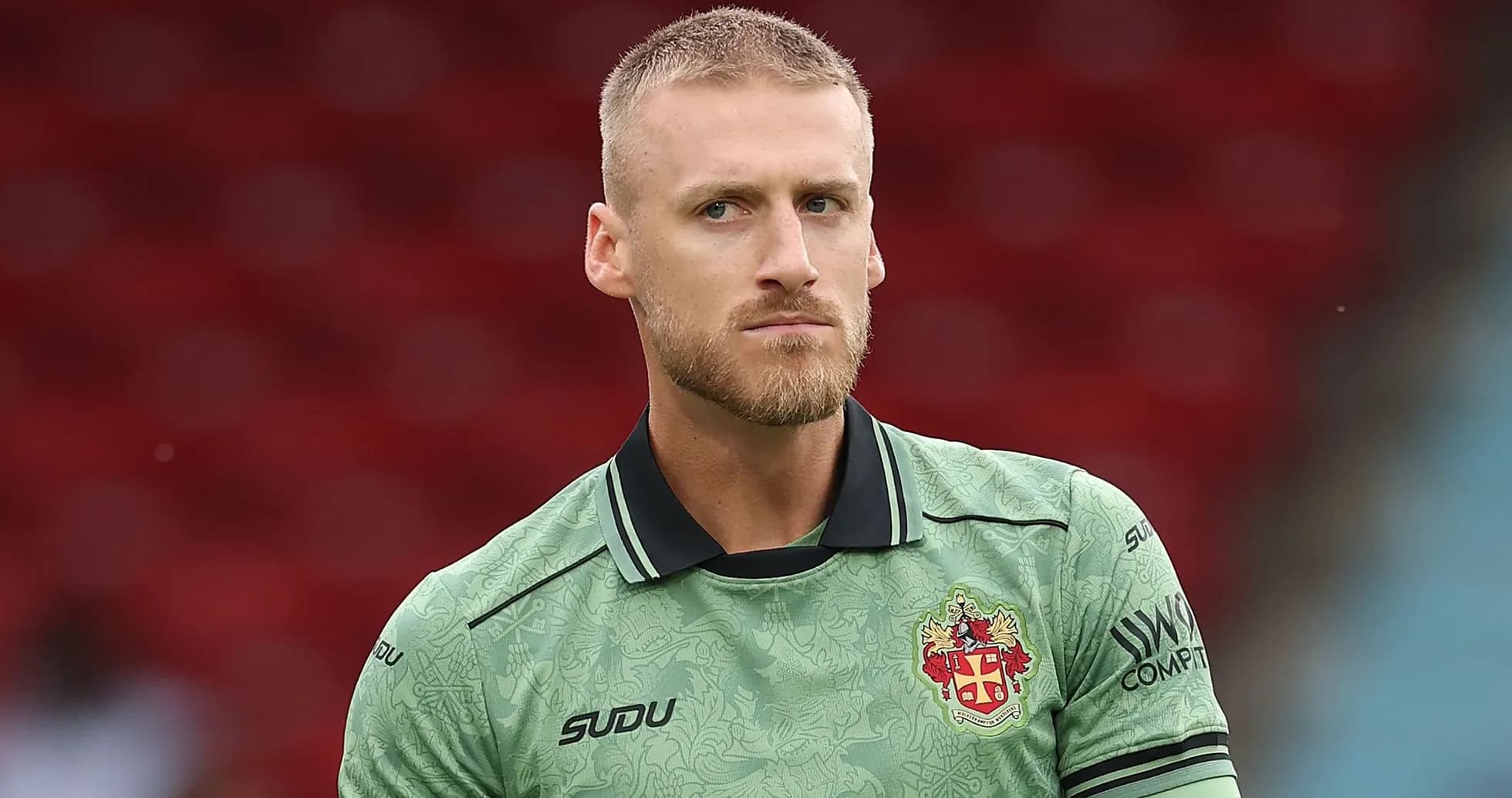 Goalkeeper in green kit during pre-match warm-up