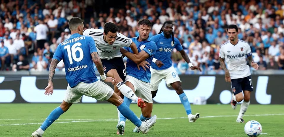 Napoli players challenging Como forward during match