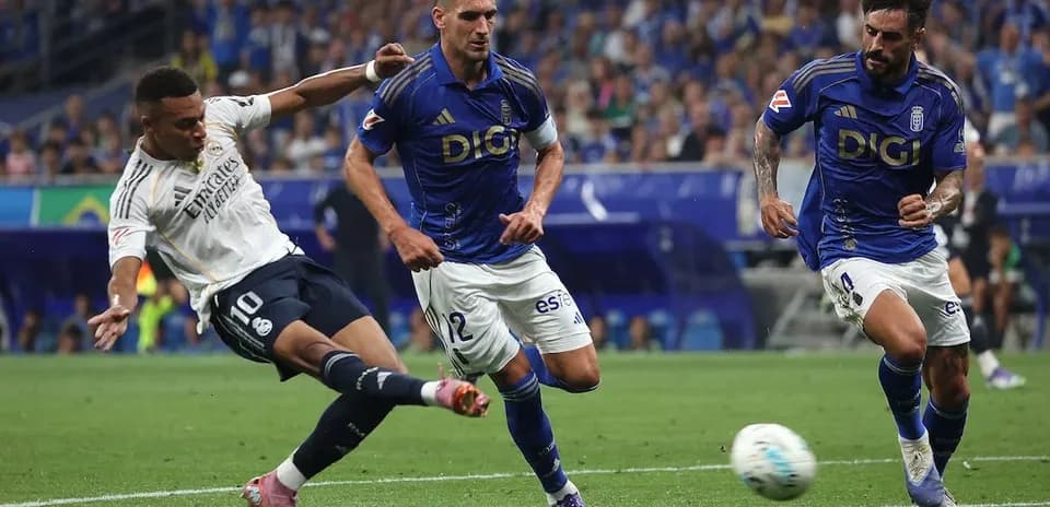 Real Madrid player dribbling against Oviedo defenders
