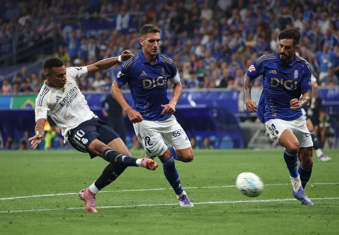 Real Madrid player dribbling against Oviedo defenders